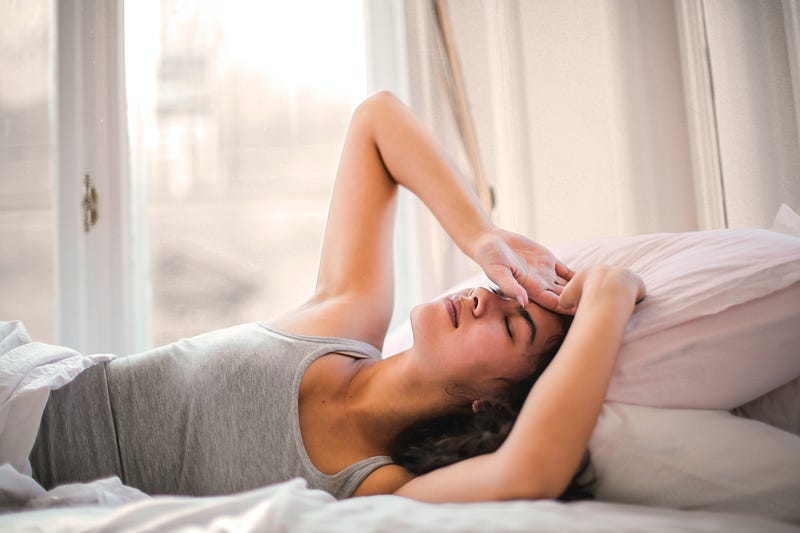 Woman relaxing in bed with a laptop